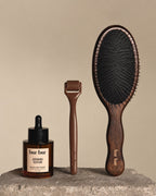 Three 'bur bur' hair care products on a stone surface with a beige background