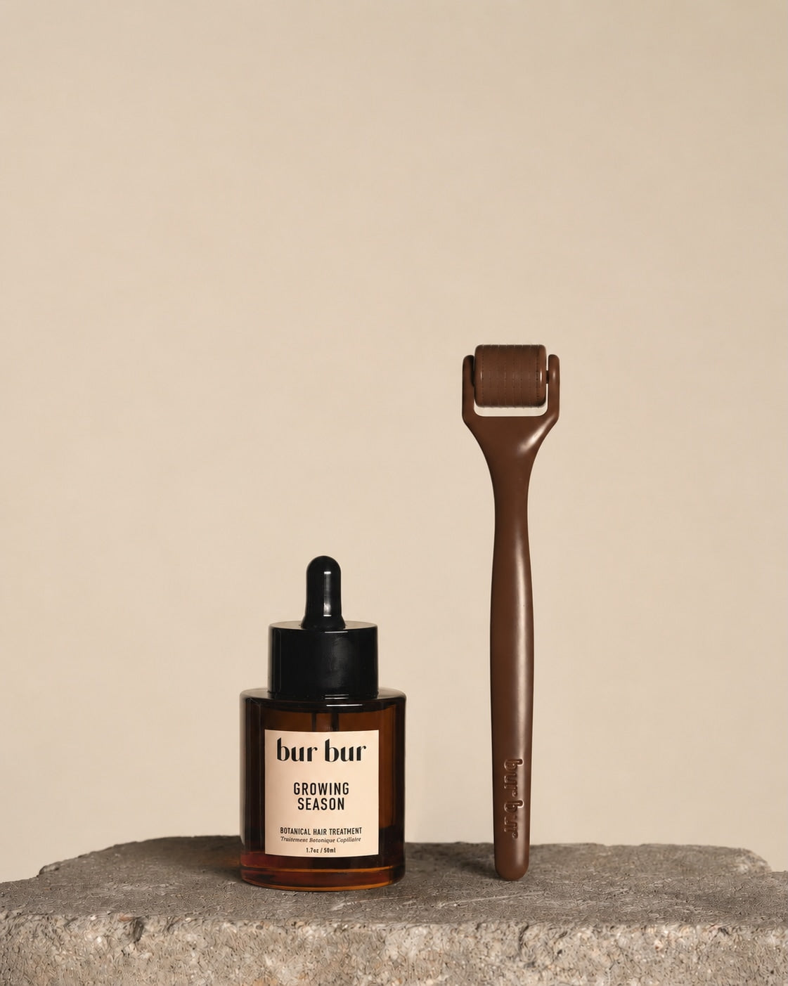 Two 'bur bur' hair care products on a stone surface with a beige background